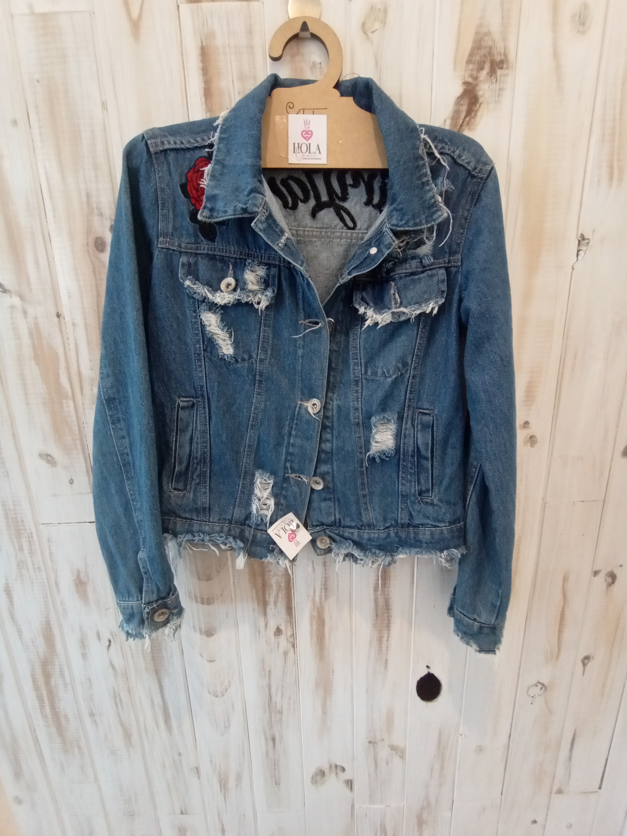 Campera de jean con roturas y rosa en el hombro